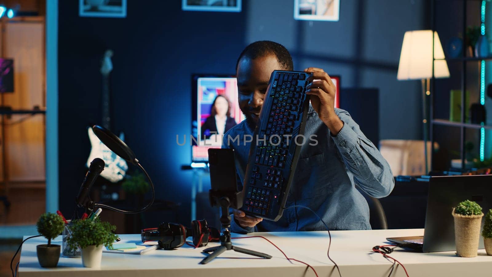 African american technology internet star filming review of newly released USB wired keyboard, mouse and headphones, giving audience feedback about comfort experience, doing endorsement