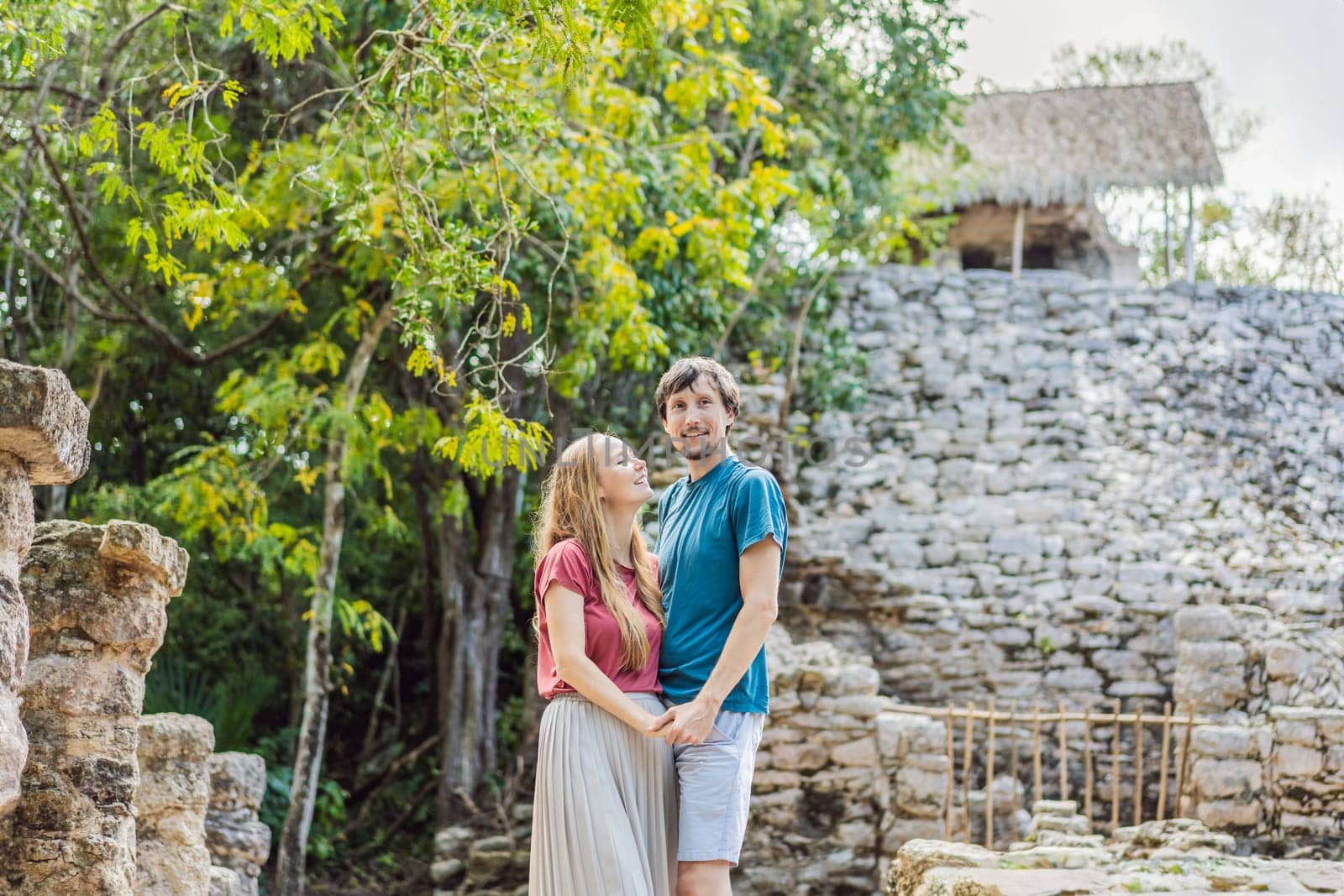 Couple, man and woman tourists at Coba, Mexico. Honeymoon Ancient mayan city in Mexico. Coba is an archaeological area and a famous landmark of Yucatan Peninsula. Cloudy sky over a pyramid in Mexico.