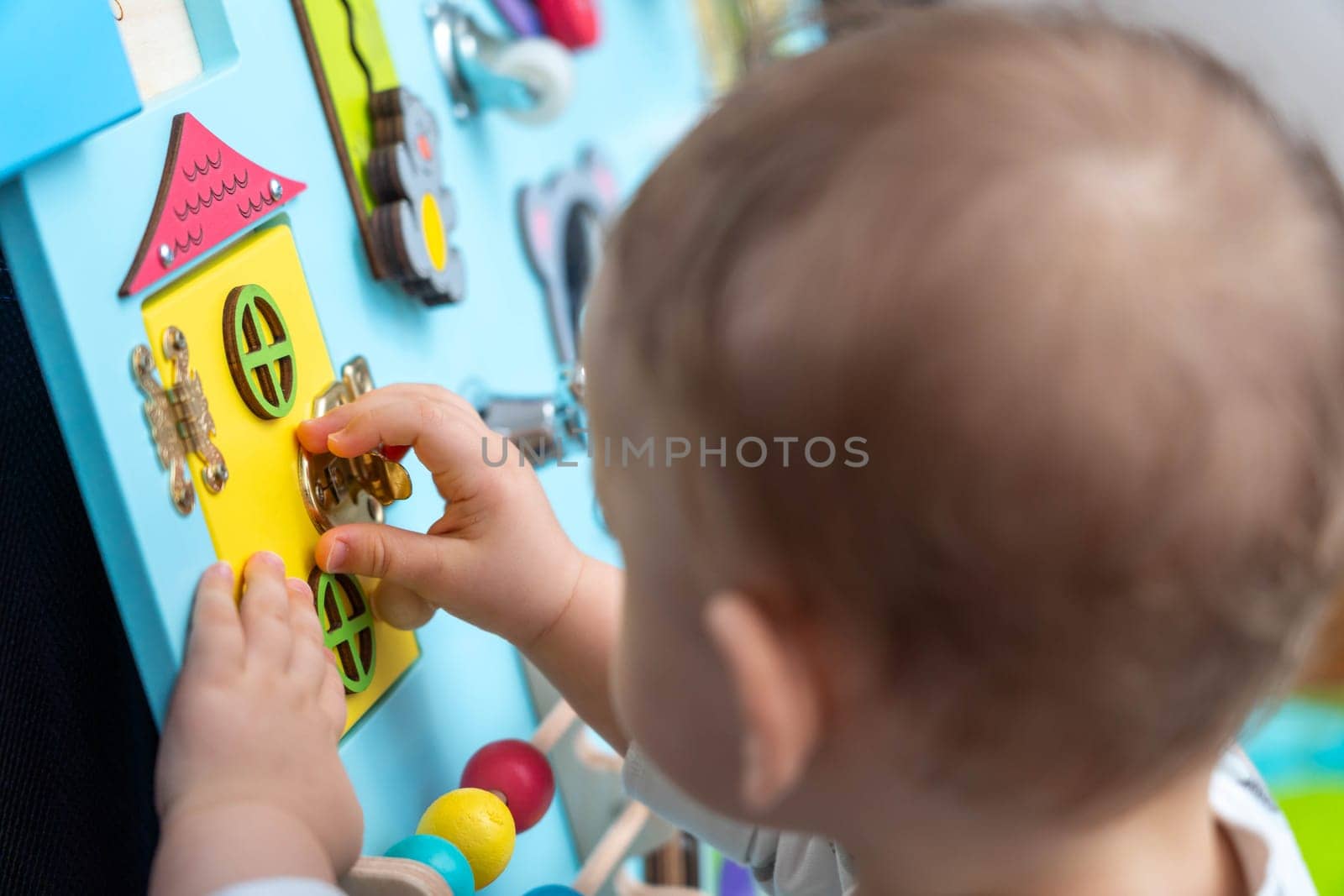 The kid is intently trying to open the lock on the game board.