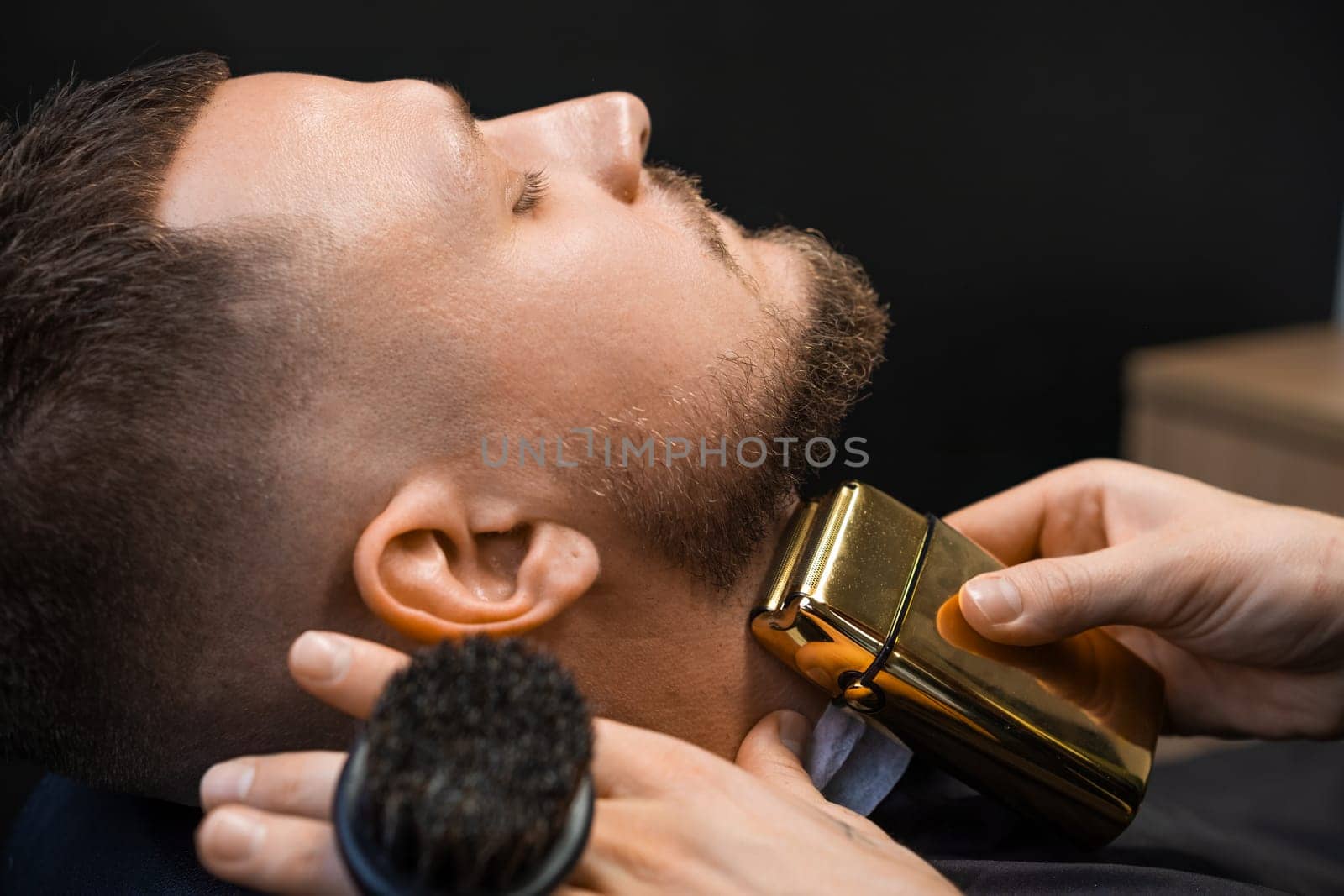 Client during beard trimming in the barbershop.
