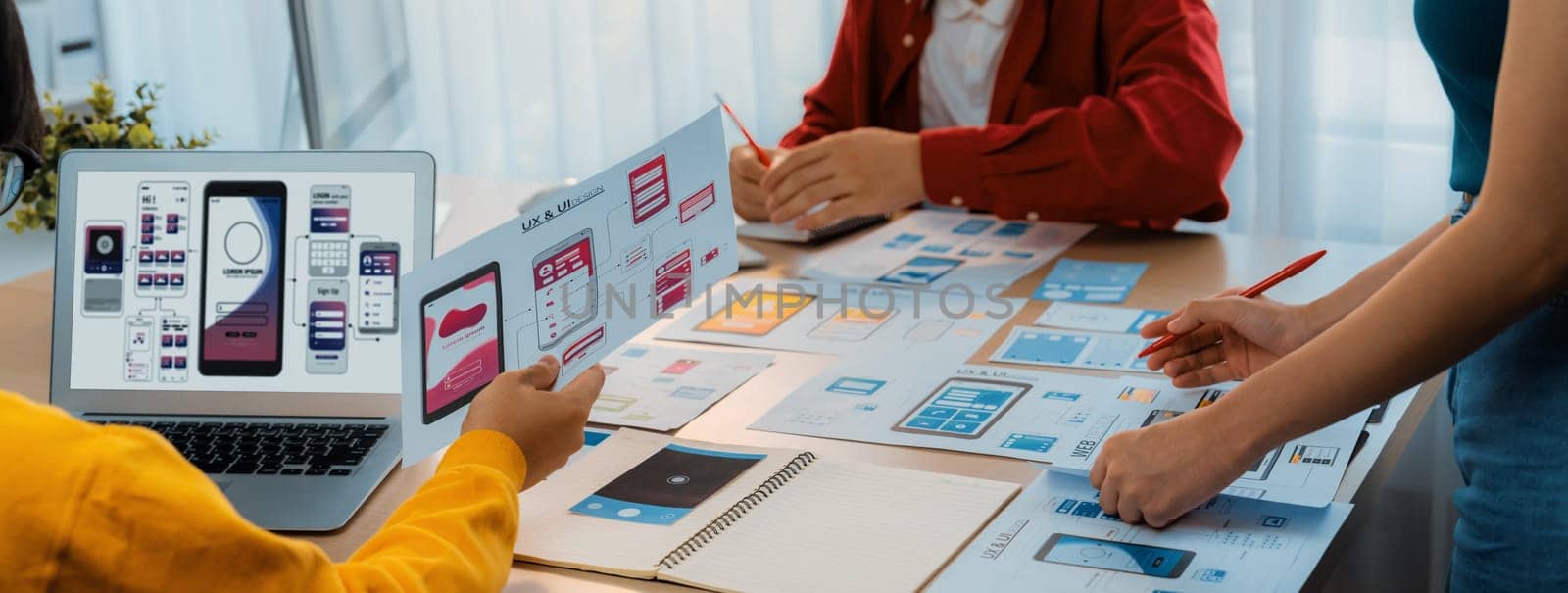 Panorama banner of startup UX developer or company employee design user interface or UI prototype for mobile application or website software with software display on laptop monitor in office. Synergic