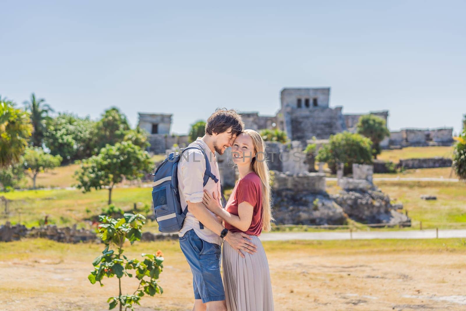 Couple man and woman tourists enjoying the view Pre-Columbian Mayan walled city of Tulum, Quintana Roo, Mexico, North America, Tulum, Mexico. El Castillo - castle the Mayan city of Tulum main temple.