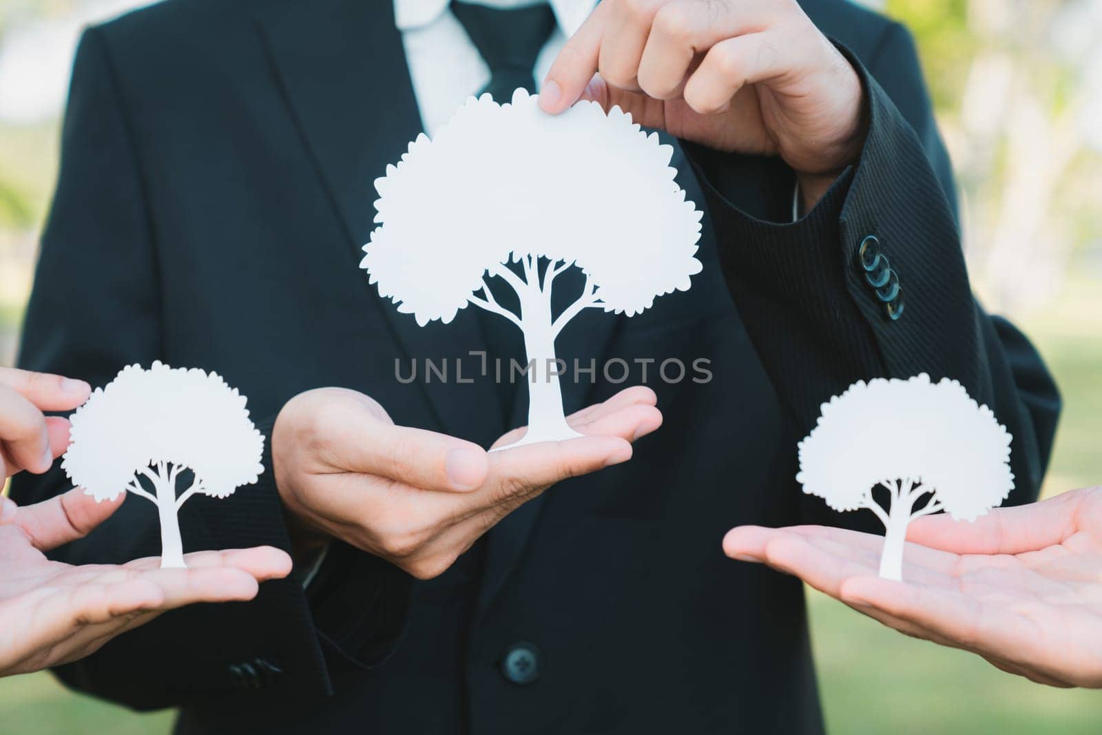 Group of business people holding white paper tree showcase environmental protection nurturing with nature, reduce CO2 and green house gases emission with reforestation for greener future. Gyre