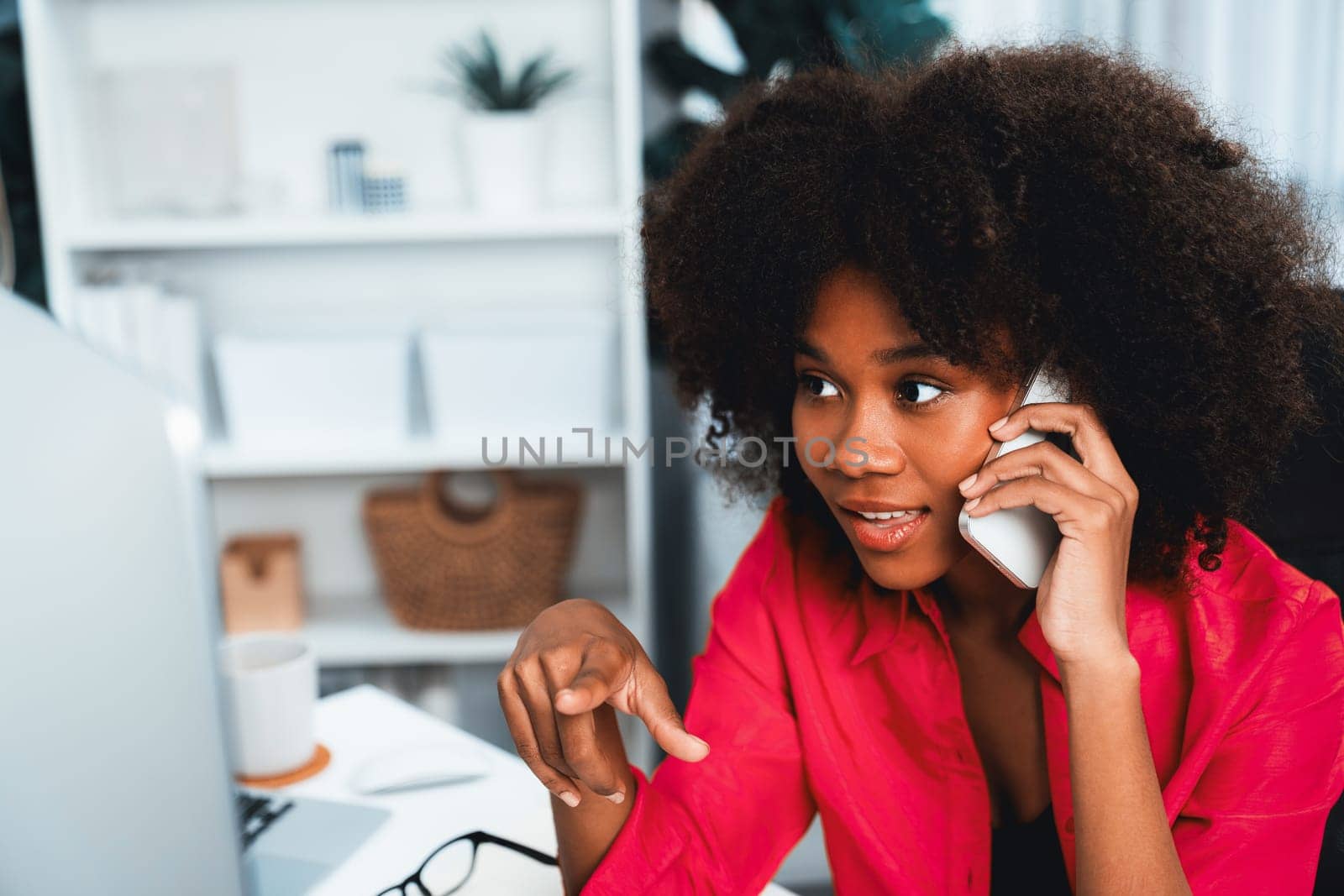 African woman talking with coworker or friend on the phone and looking at the screen with happy face. Achievement for promoting job position in the company with the good news life. Tastemaker.