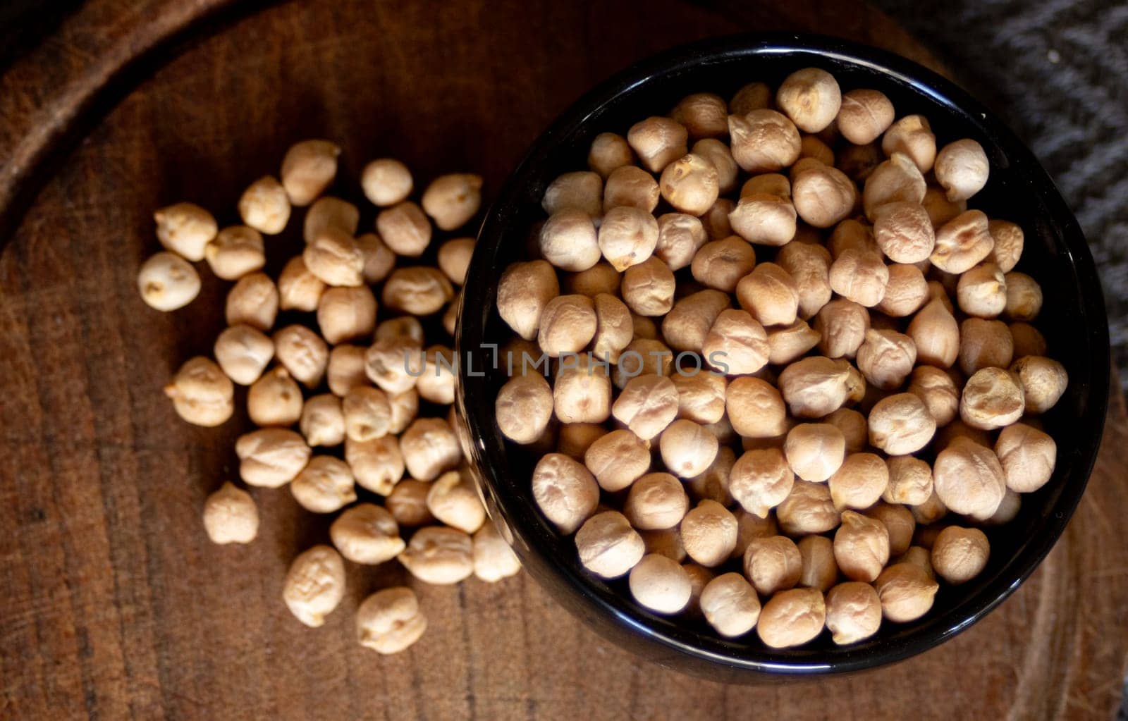 Chickpeas in black bowl . Dark background. Cenital photo by VeroDibe