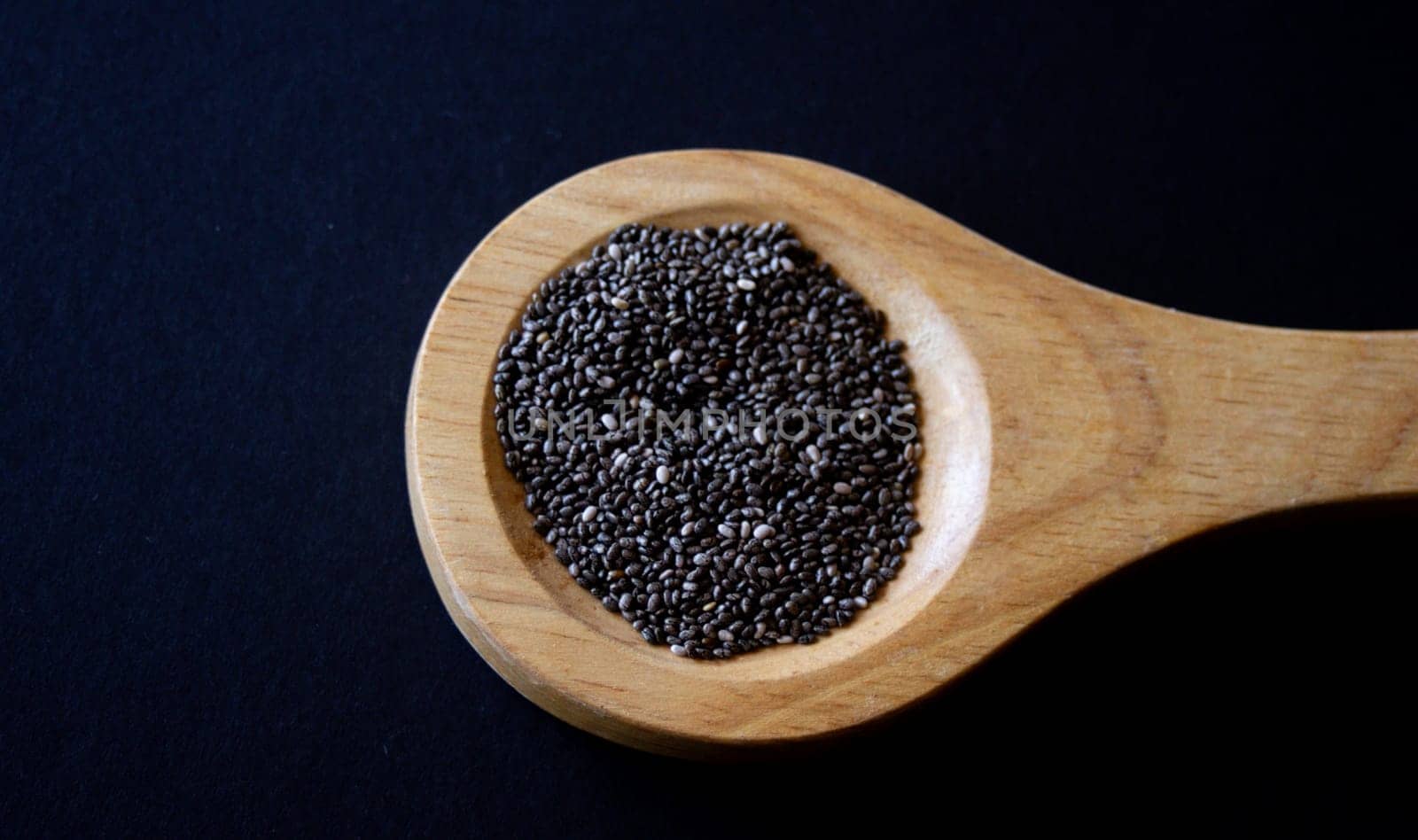 Wooden spoon with chia grains. Still life. Horizontal photo by VeroDibe