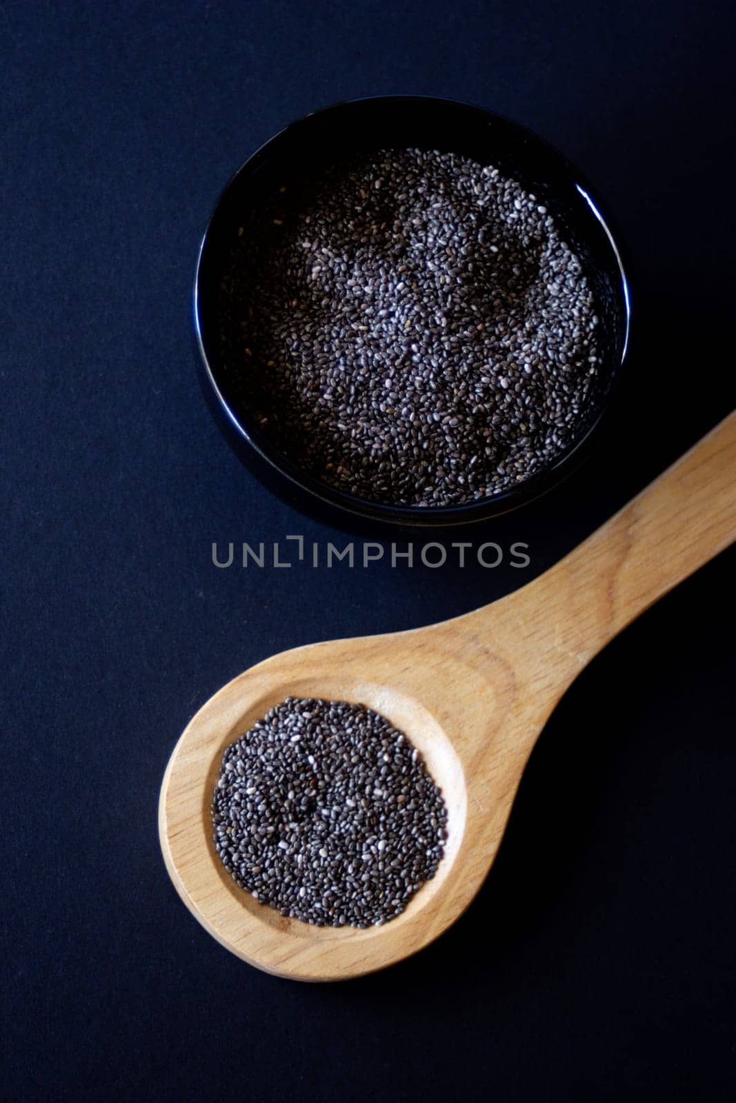 Vertical close up photo of wooden spoon with chia grains. Still life.  by VeroDibe