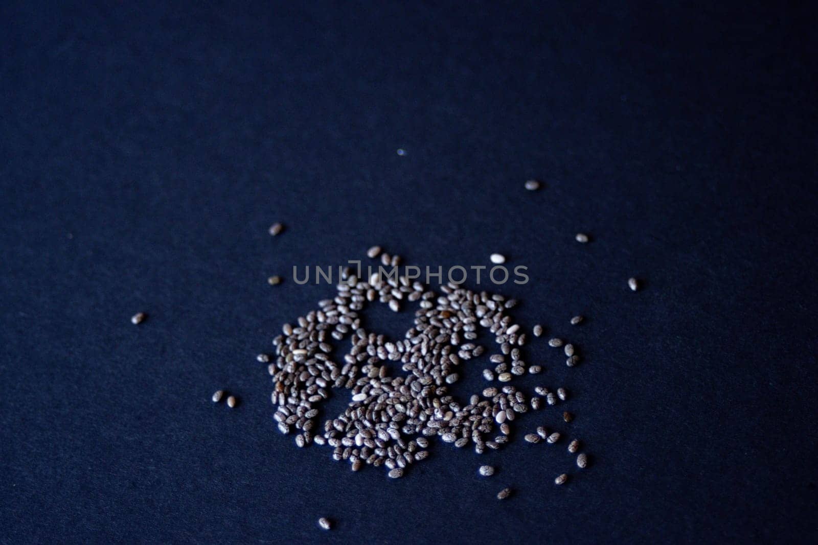 Group of chia grains in black background.Still life. Horizontal photo by VeroDibe