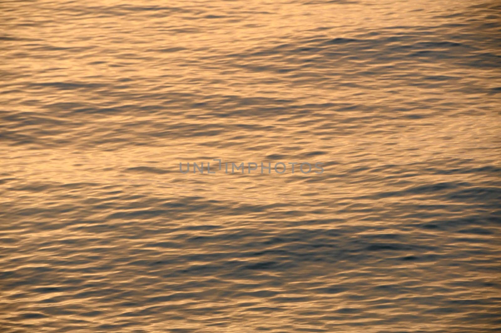beautiful sunset of the Mediterranean sea, waves of golden color at sunset