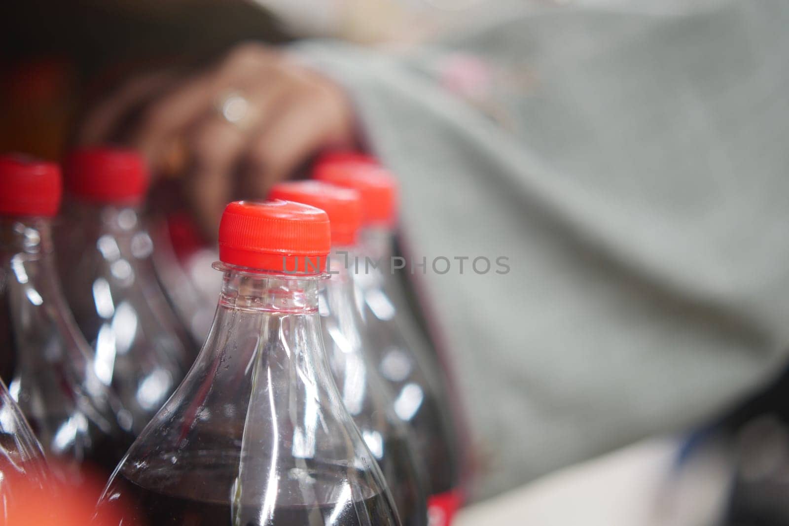 plastic bottles of soft drink in a shelf .