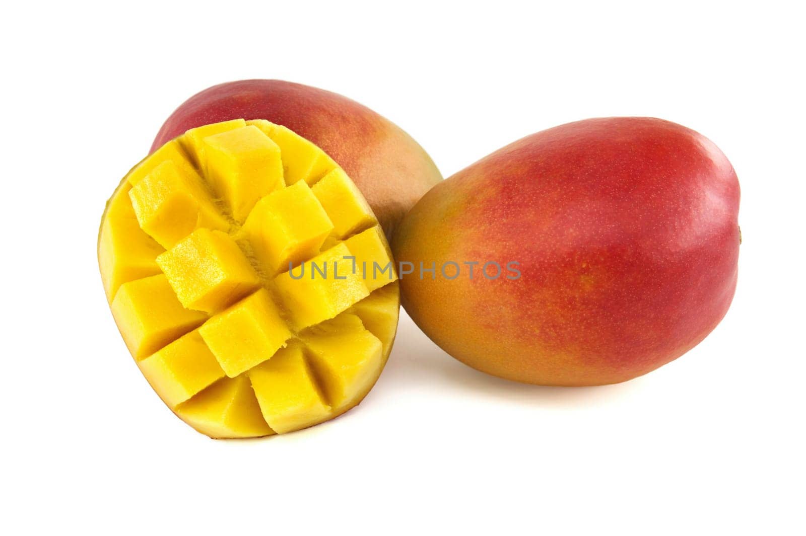 Ripe mango with crimson and yellow skin close to sliced half of a mango with cubed meat