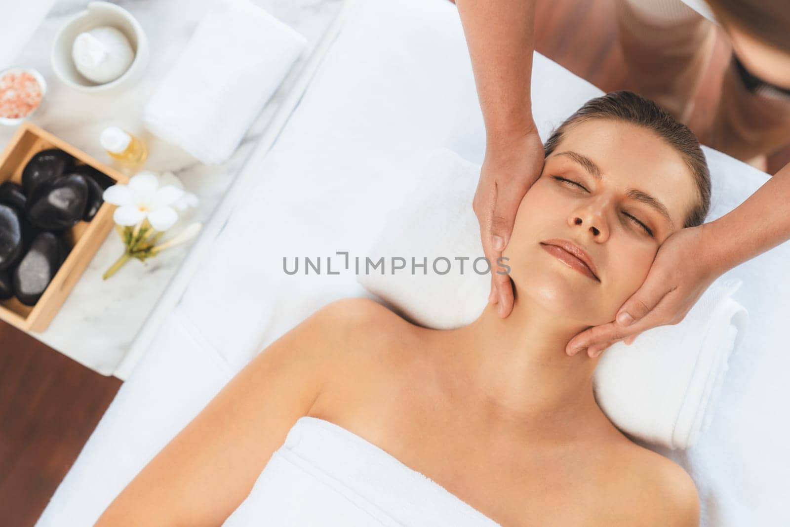 Panorama top view of woman enjoying relaxing anti-stress head massage and pampering facial beauty skin recreation leisure in dayspa modern light ambient at luxury resort or hotel spa salon. Quiescent