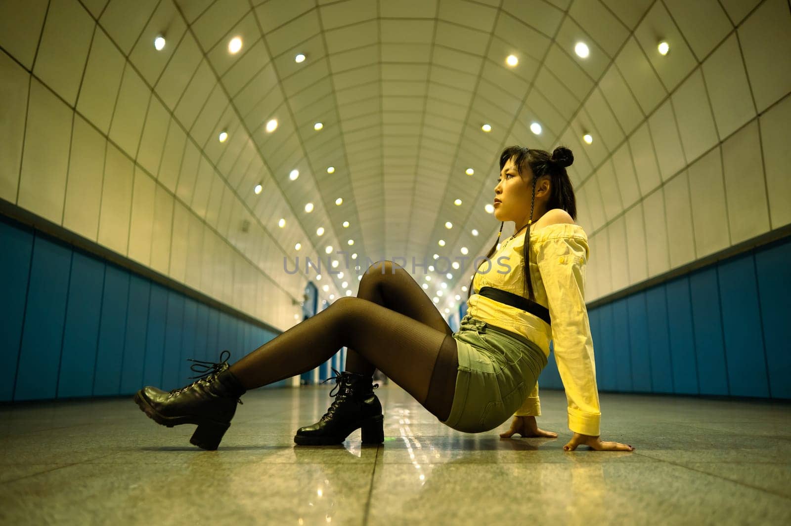 Asian young woman posing in the subway passage