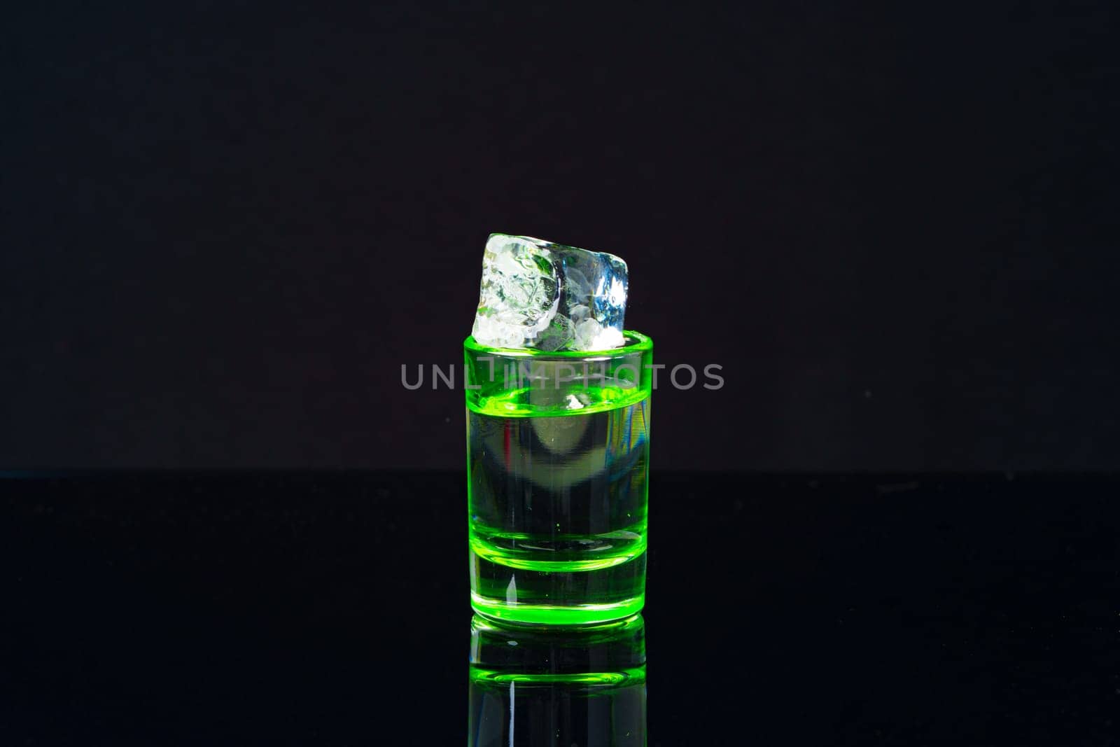 Green shot cup on black background close up photo