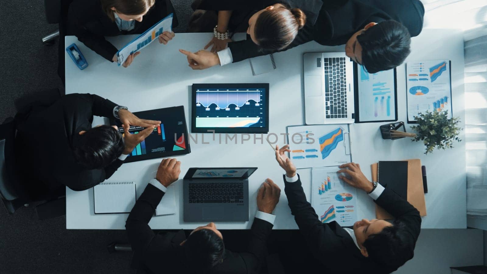 Top view of smart business people brainstorm marketing idea at meeting table while compare stock market investment data between laptop and tablet. Business team planning financial plan. Directorate.