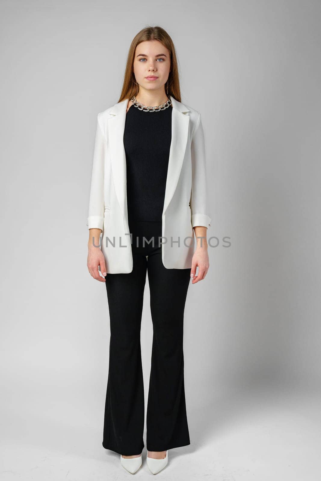 Woman in Black Top and White Jacket Posing in Studio close up