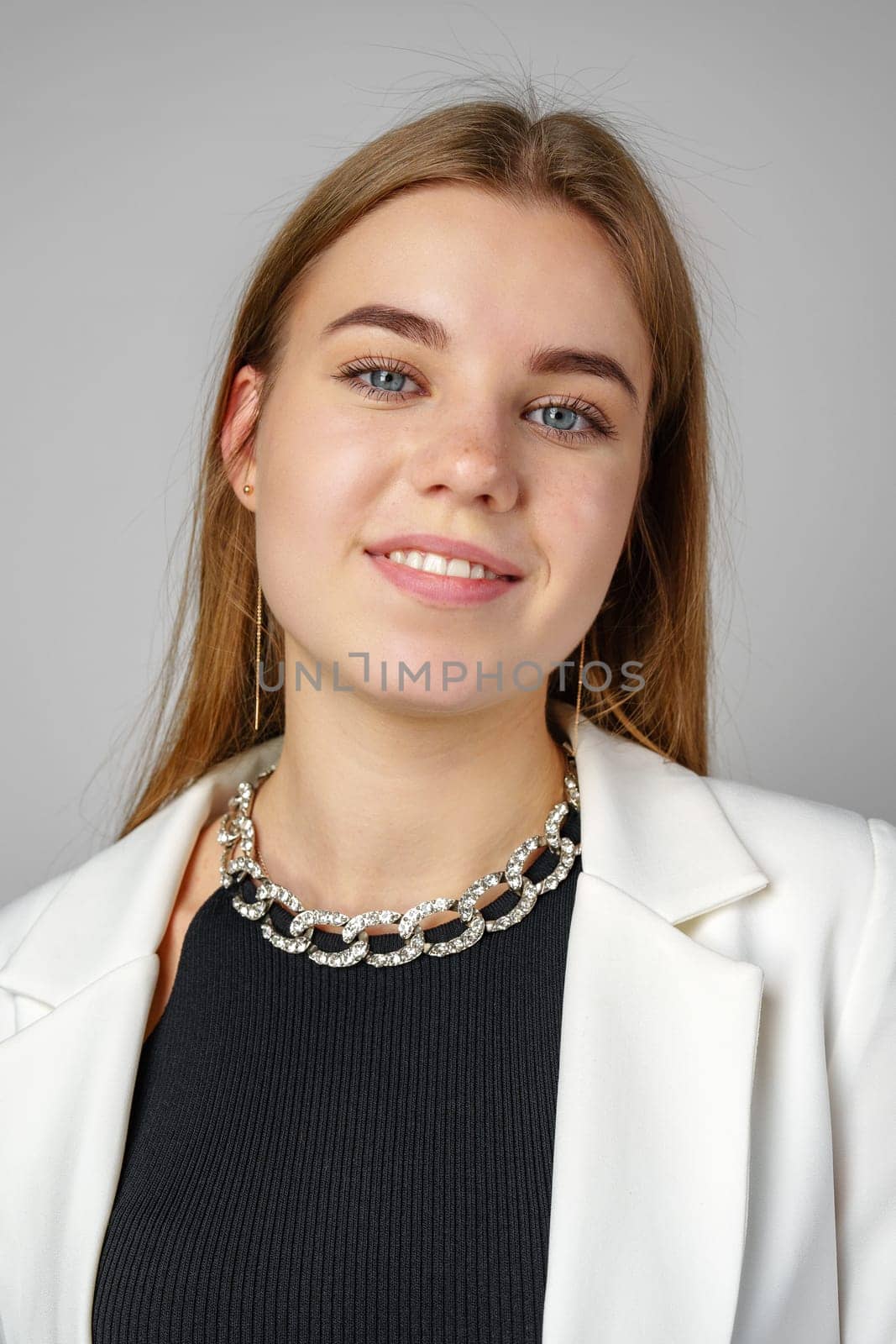 Woman in Black Top and White Jacket Posing in Studio close up