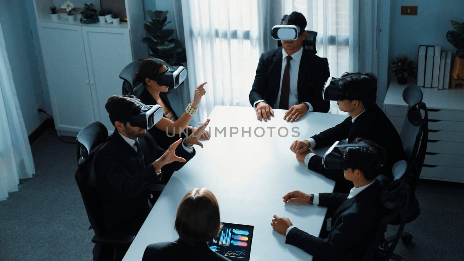 Top view of manager working on laptop and sending data analysis to business people by using VR glass headset while diverse team planning marketing strategy and looking at financial graph. Directorate.