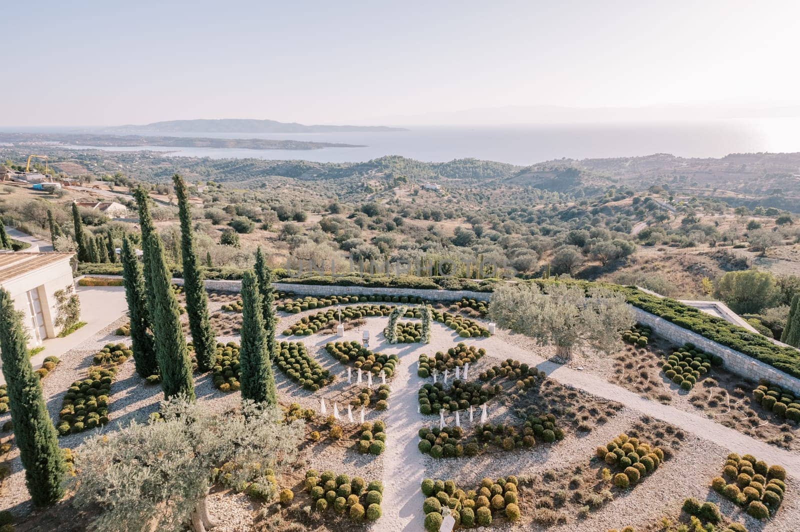 Sectoral garden with round bushes and tall trees on a mountainside. Hotel Amanzoe, Peloponnese, Greece. High quality photo