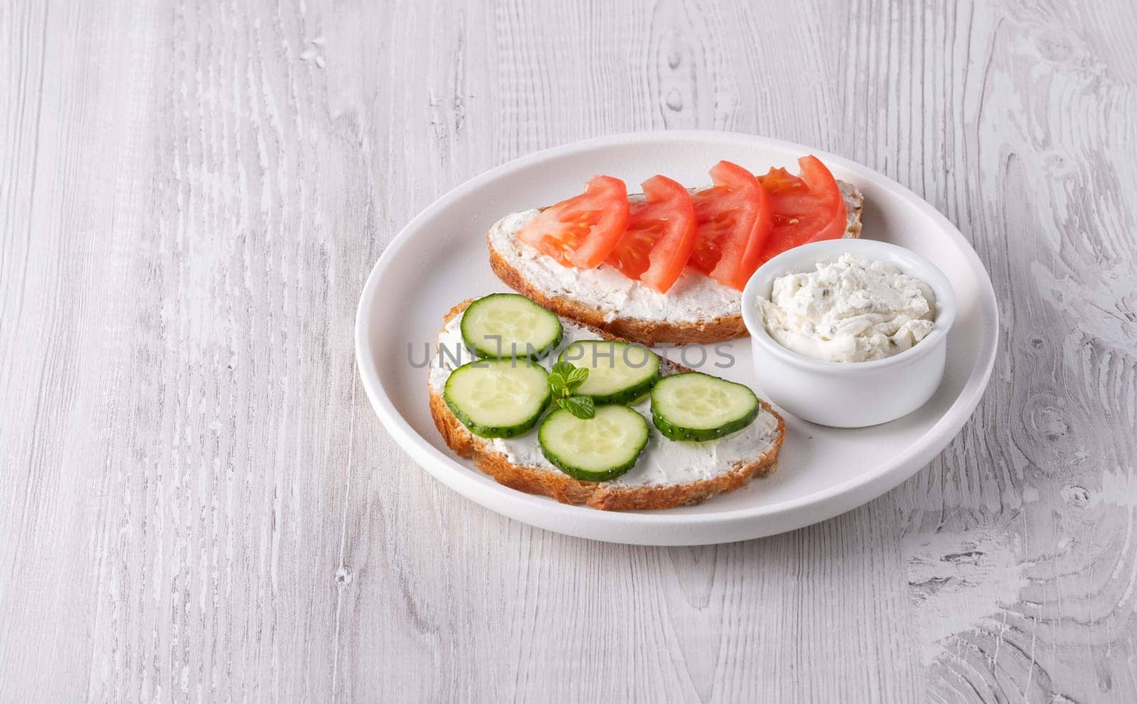 Healthy sandwiches with white cottage cheese, cucumber and tomato, with copy space for text.