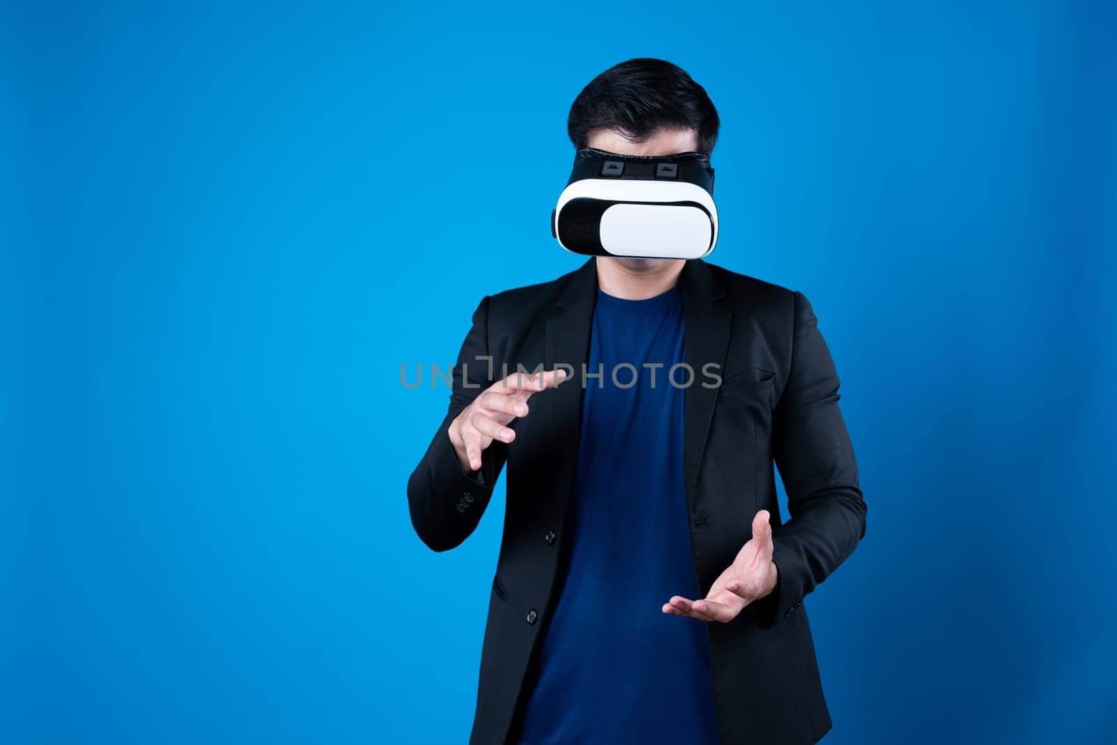 Profile of businessman wearing VR device connecting metaverse, holding stuff in the air isolated blue background futuristic analytics communication technology virtual reality copyspace. Contrivance.