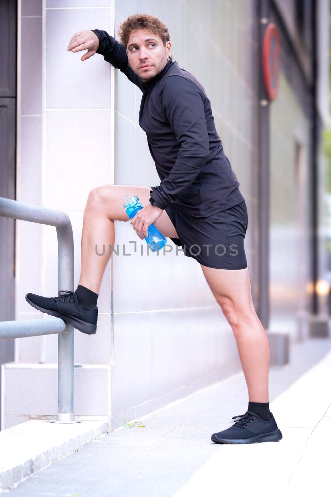 young man and sporty doing arm stretches outdoors.