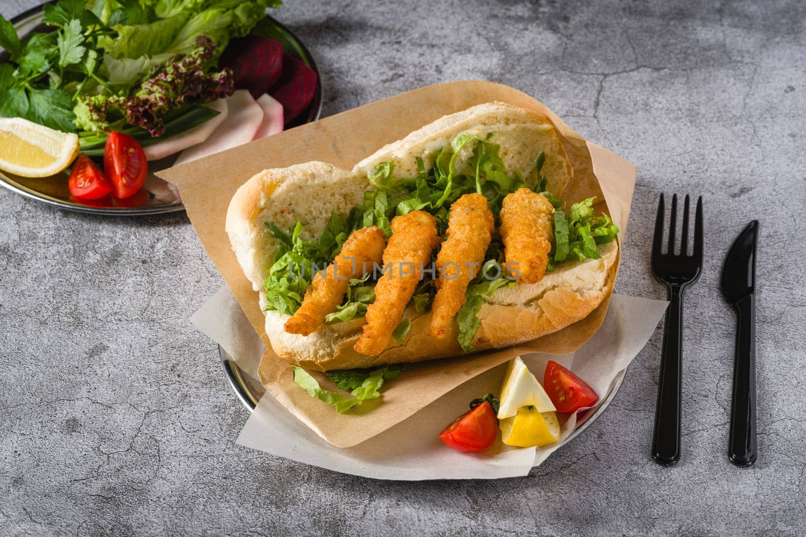 Deep fried shrimp in bread with greens on the side. Shrimp sandwich