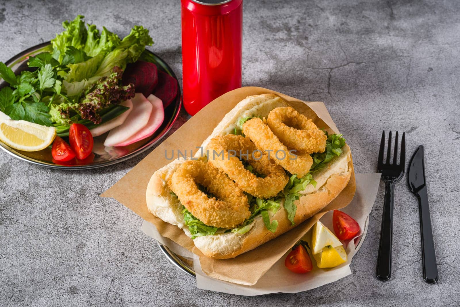 Deep fried squid in bread with greens on the side. Squid sandwich