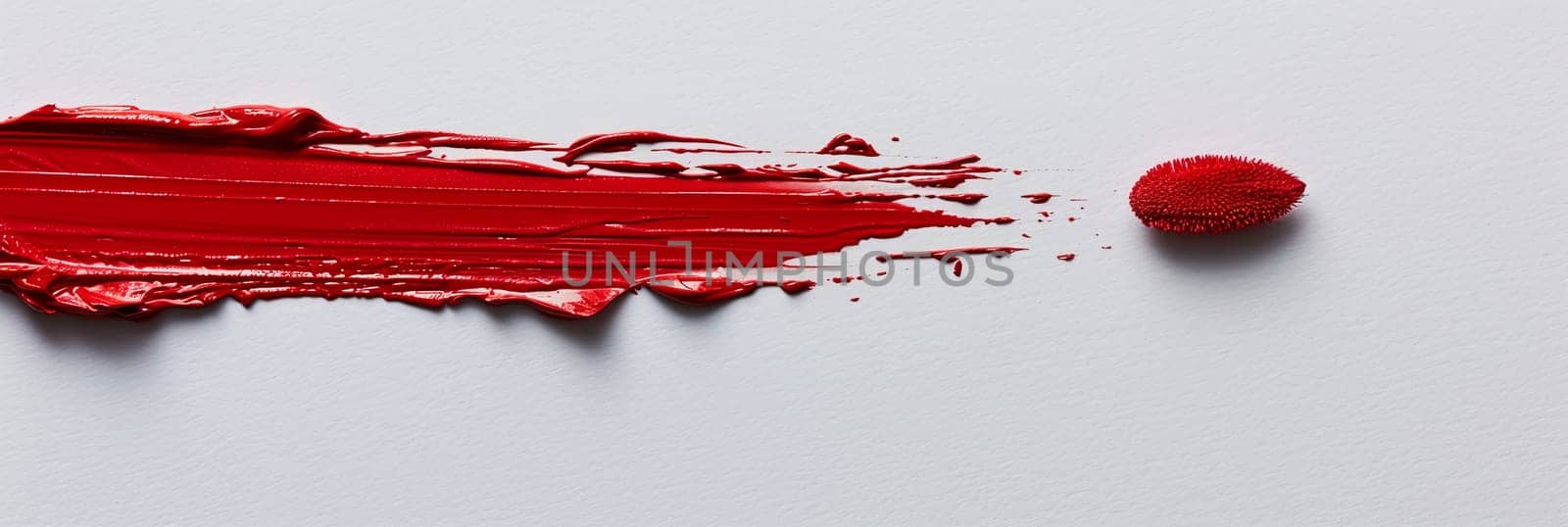 A close-up of a classic red lipstick smudge on a white surface, leaving a subtle yet powerful mark.