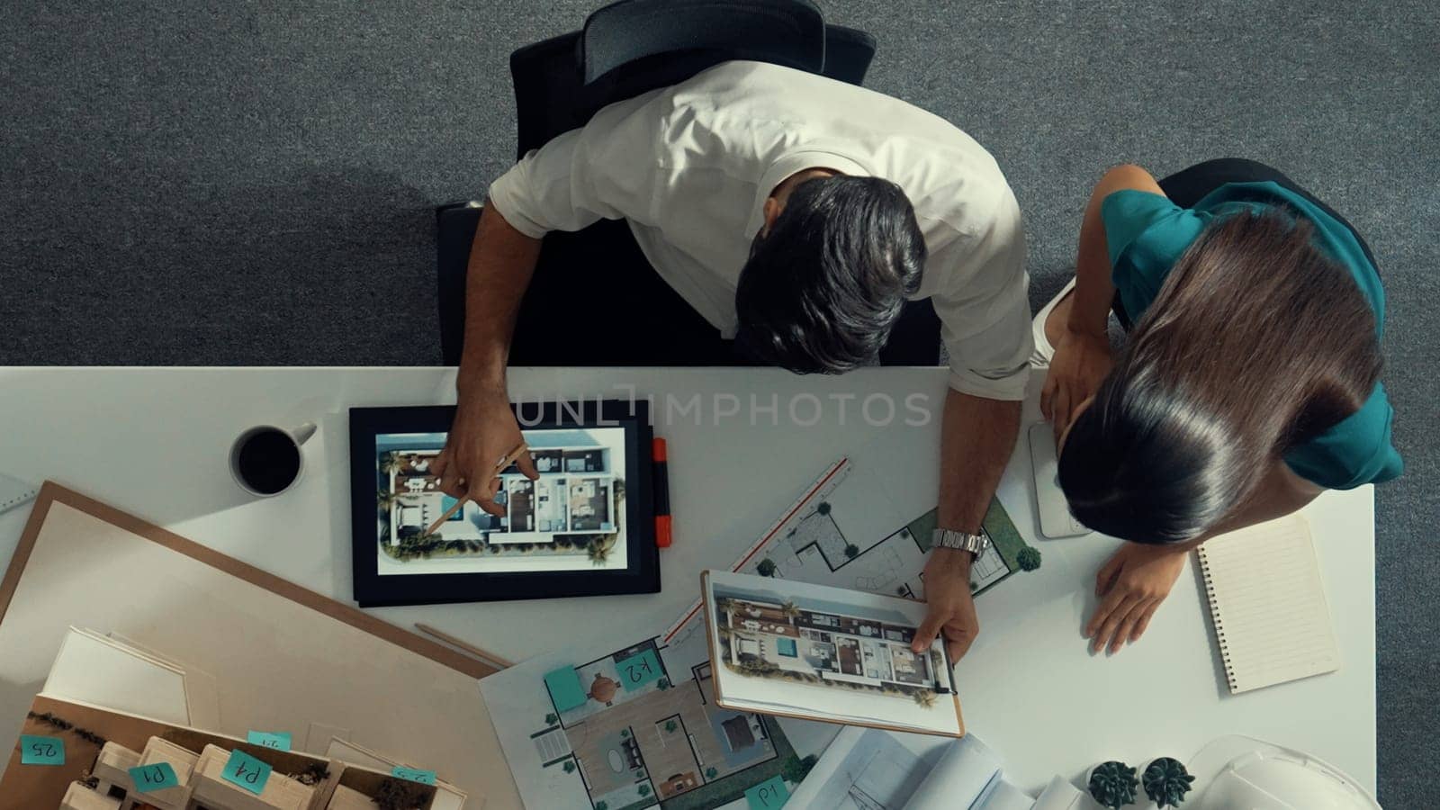 Top view of business man working together to design house. Aerial view of architect engineer looking at tablet display blueprint. Aerial view of manager discussing about house structure. Alimentation.