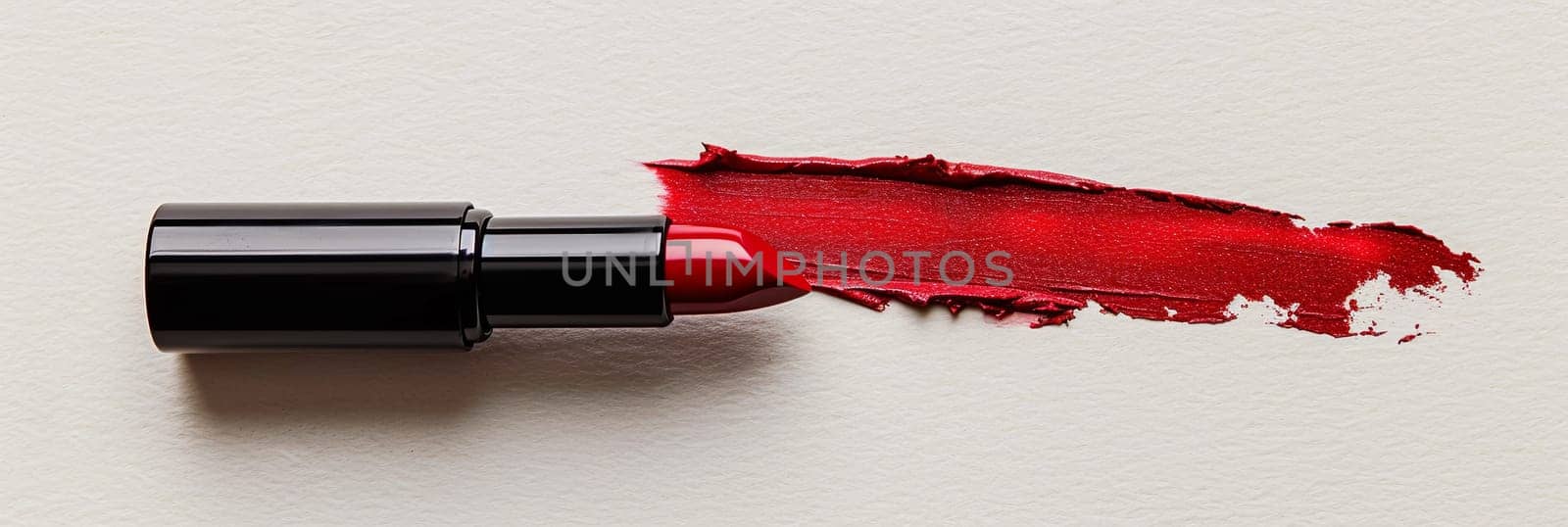 A close-up of a classic red matte lipstick leaving a vibrant swatch line on a pristine white surface.