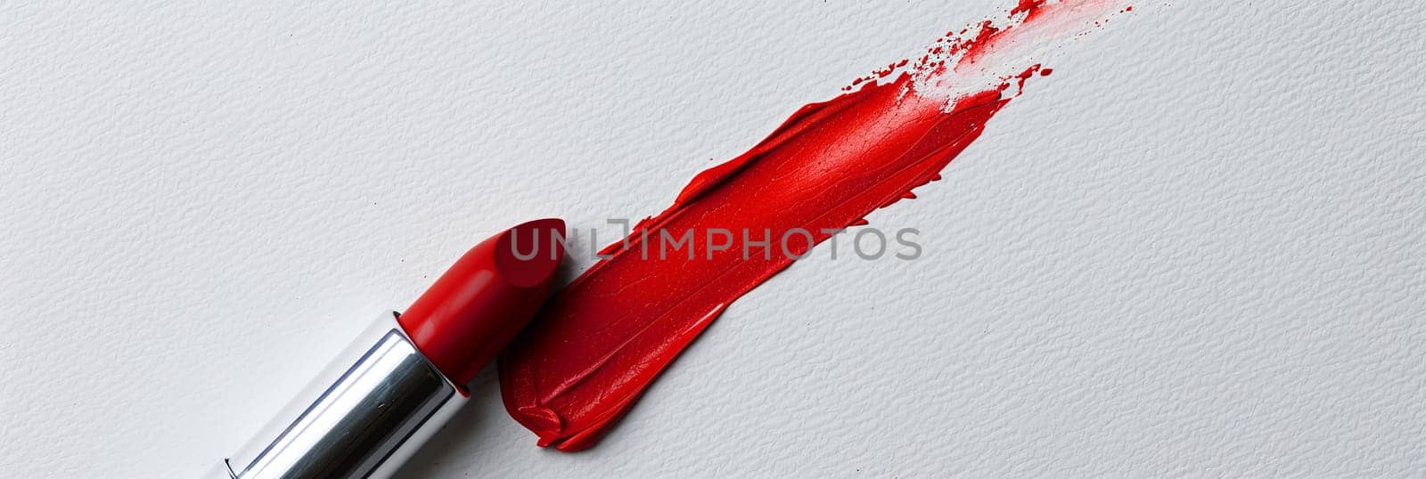 Red lipstick leaves a striking swatch on a white surface, showcasing its classic matte finish.