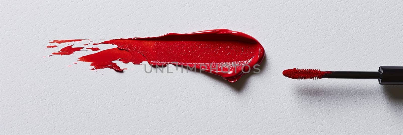 Close up of a vibrant red lipstick creating a swatch on a pristine white surface, leaving a smear of classic matte beauty.