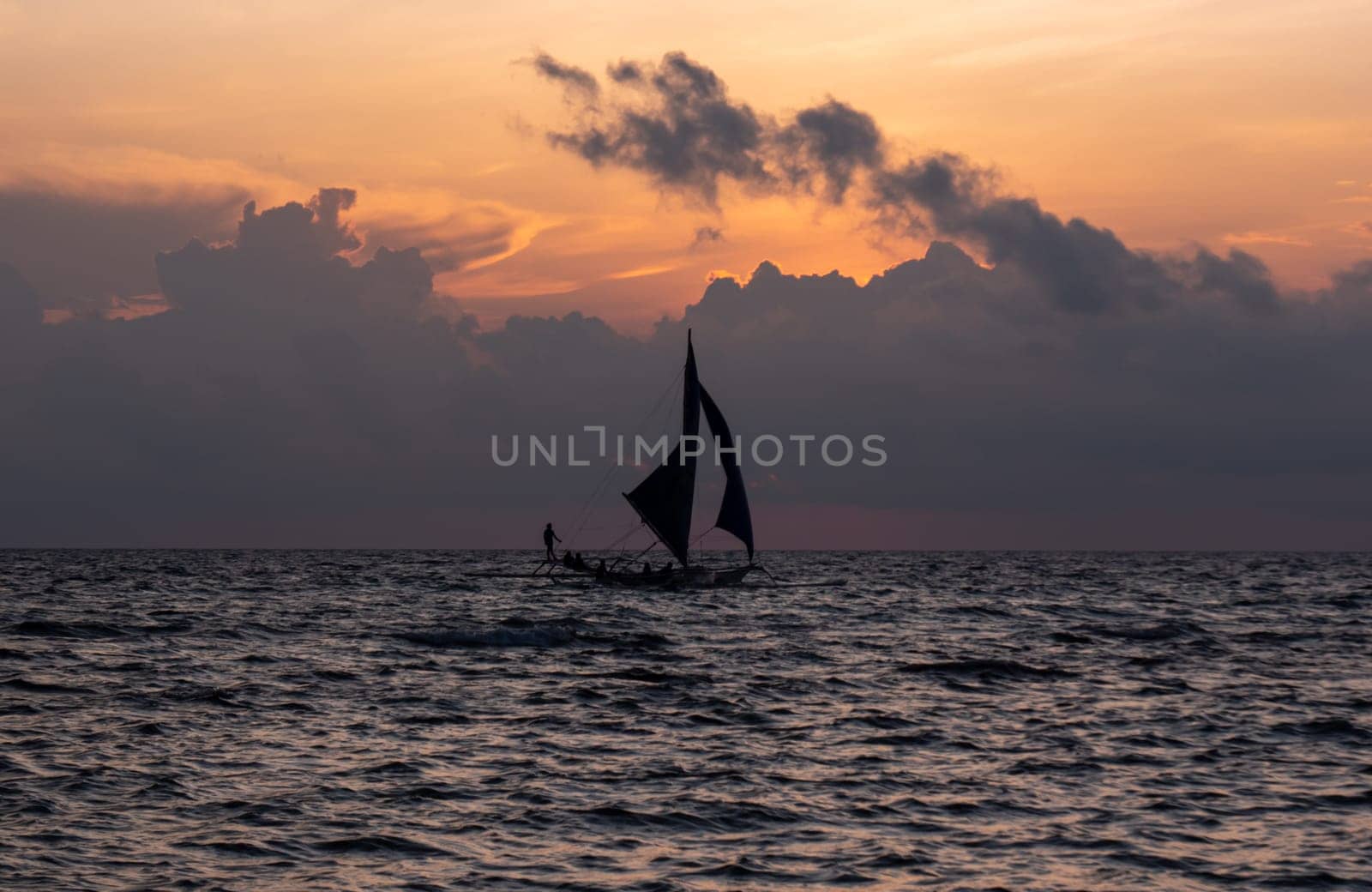 Calm evening on a sandy beach with boat sailing in the distance. Boracay, Philippines. by Busker