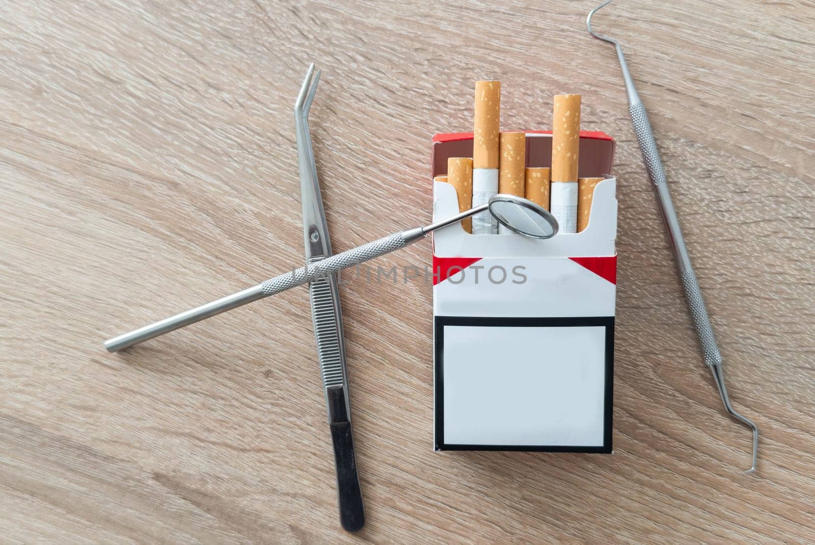 Image of dental tools with cigarettes on the table background. High quality photo