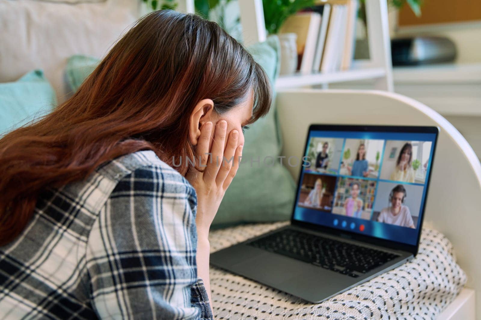 Young female having video conference with group of teenage students on laptop by VH-studio