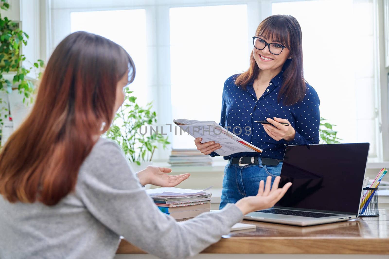 Female teacher mentor teaching young teenage girl student using laptop computer by VH-studio