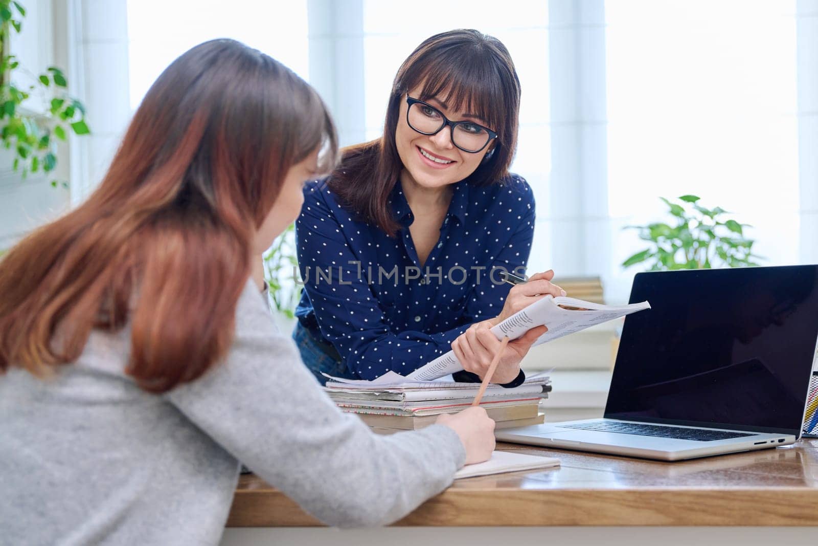 Female teacher mentor teaching young teenage girl student using laptop computer by VH-studio