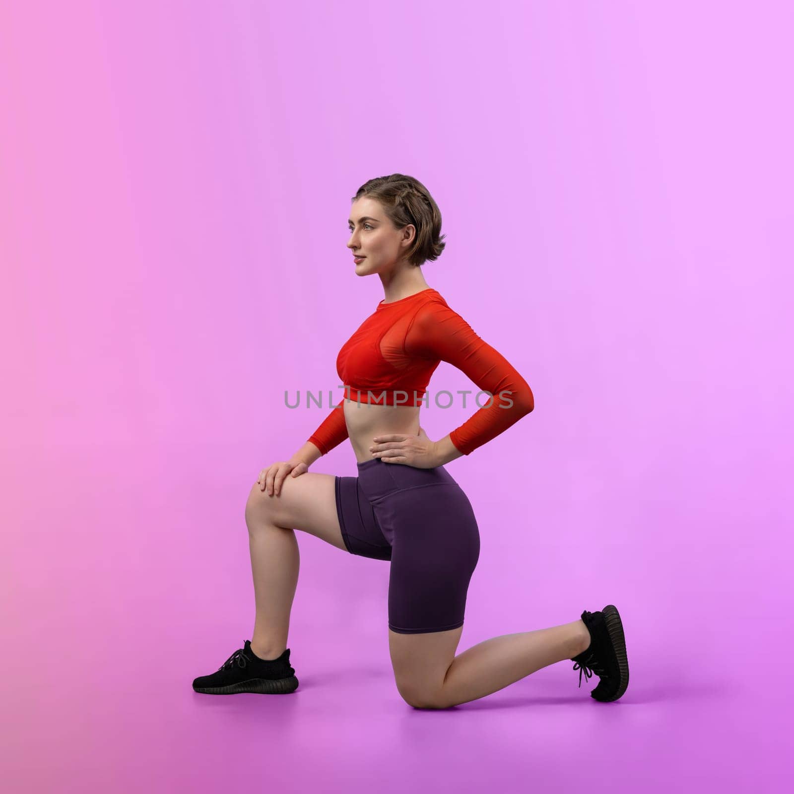 Full body length gaiety shot athletic sporty woman in fitness exercise posture by biancoblue