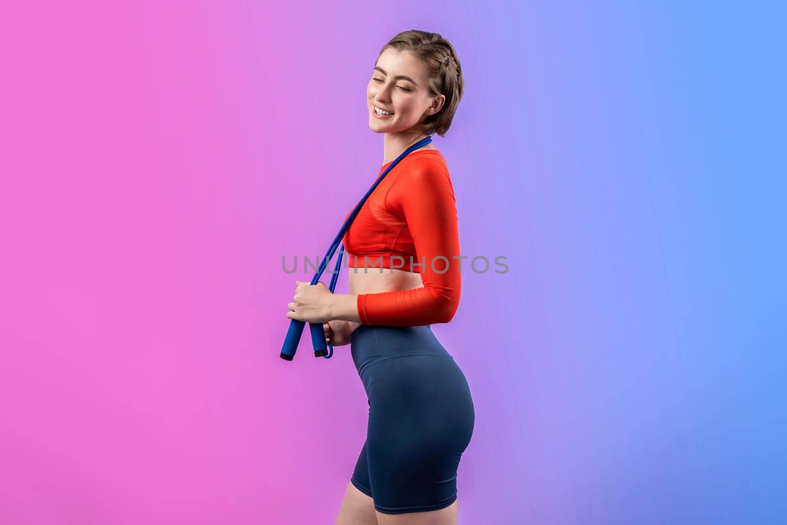 Full body length gaiety shot athletic and sporty young woman with fitness skipping rope in standing posture on isolated background. Healthy active and body care lifestyle.