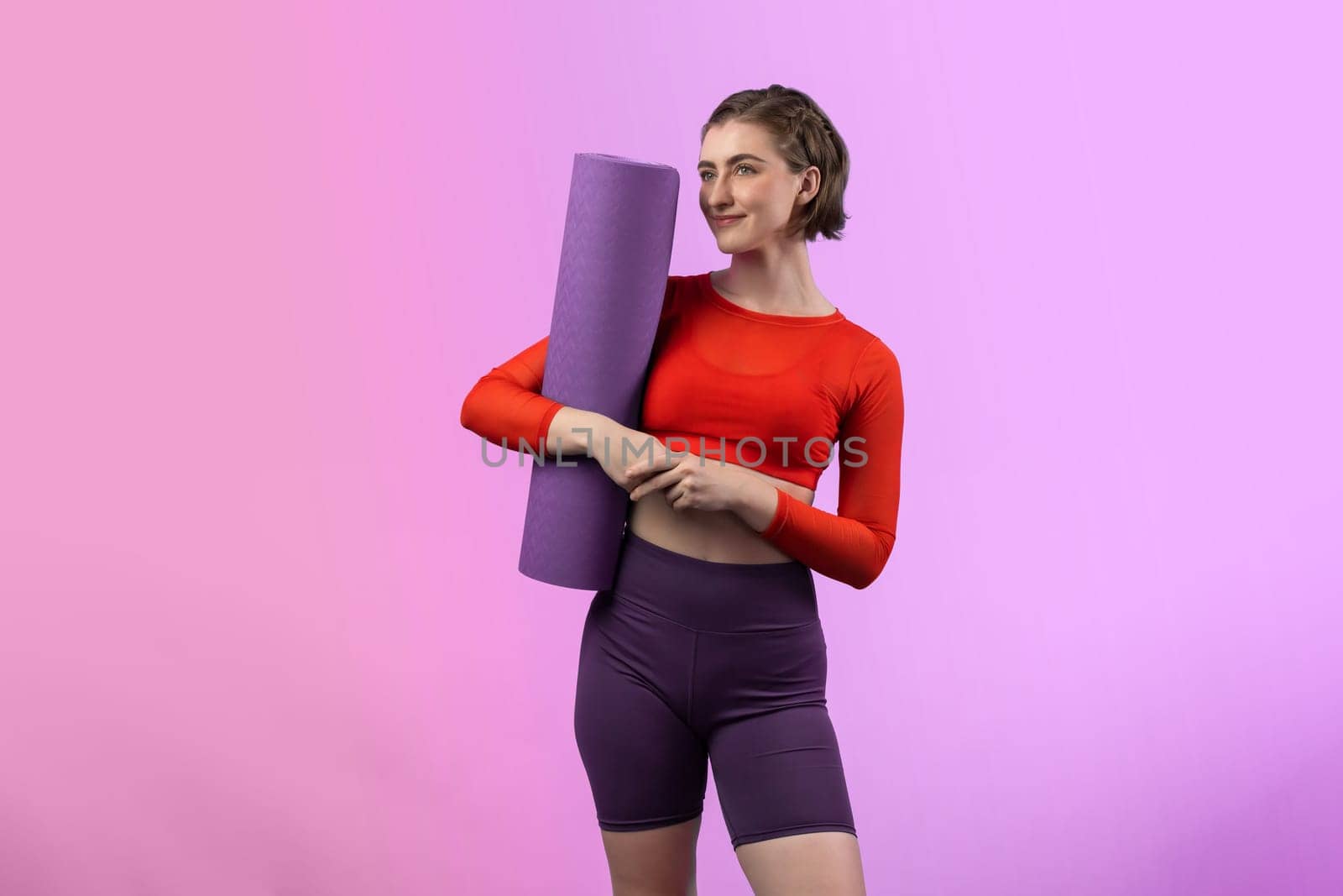 Full body length gaiety shot athletic and sporty young woman with fitness matt in exercise posture on isolated background. Healthy active and body care lifestyle.