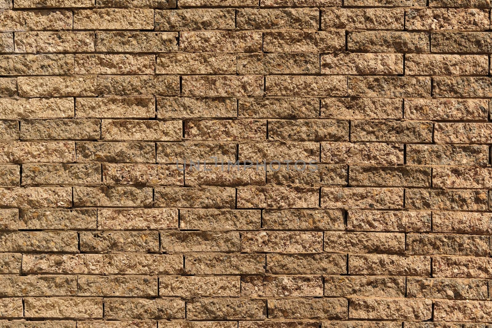 Close-up view of a textured brick wall, showcasing the intricate patterns and details of individual stones creating an abstract composition.