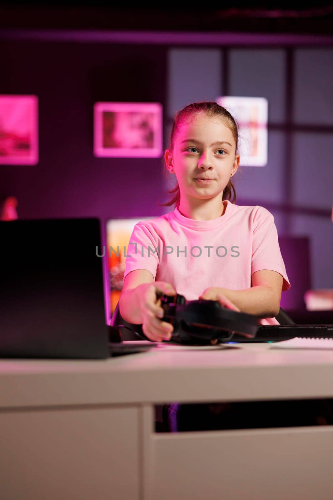 Smiling girl presents headphones in different price ranges to audience, comparing them to find winner, filming in pink neon lit studio. Gen Z child recommends songs listening devices to fans