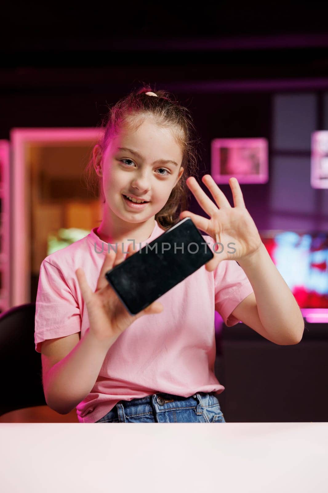 Portrait of content creator kid excited to review newly launched cellphone, comparing features with older models. Generation Z influencer filming video analyzing phone specifications