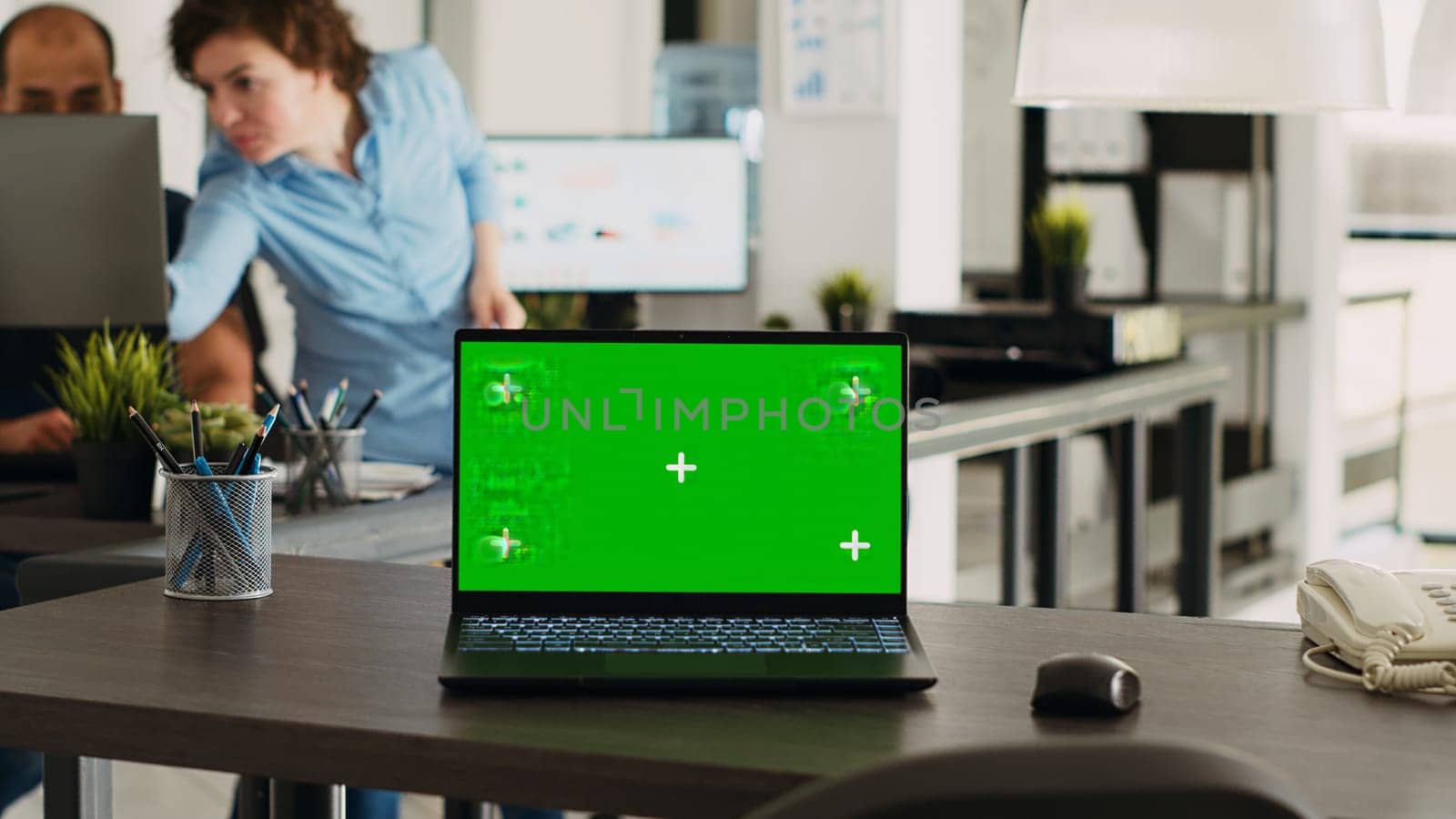 Urban coworking space desk with greenscreen design and copyspace on display at empty seat. Chromakey screen technology is used by smaller enterprises, isolated mockup layout on laptop.