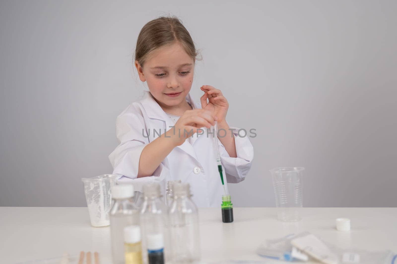 Caucasian girl doing chemical experiments on a white background