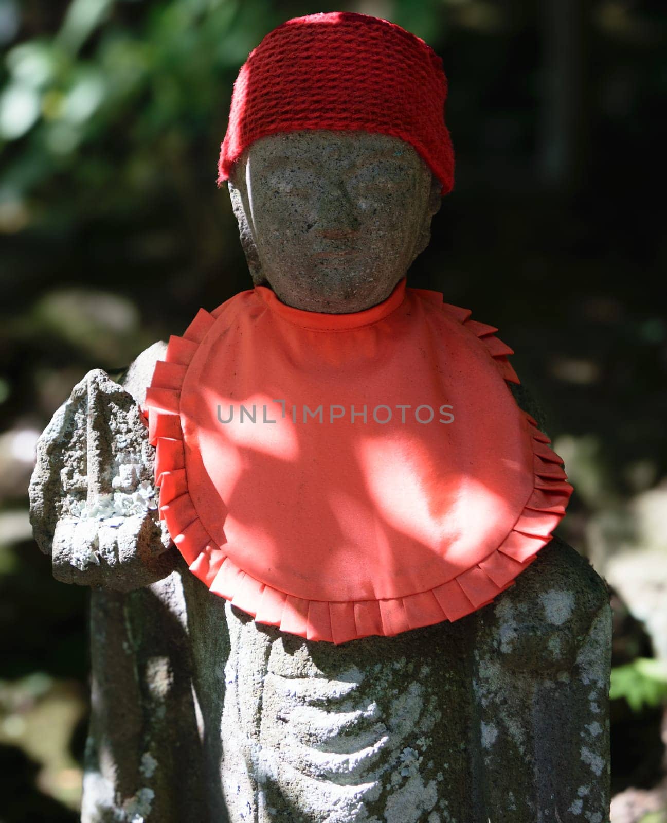 A small stone statue with a knitted hat.