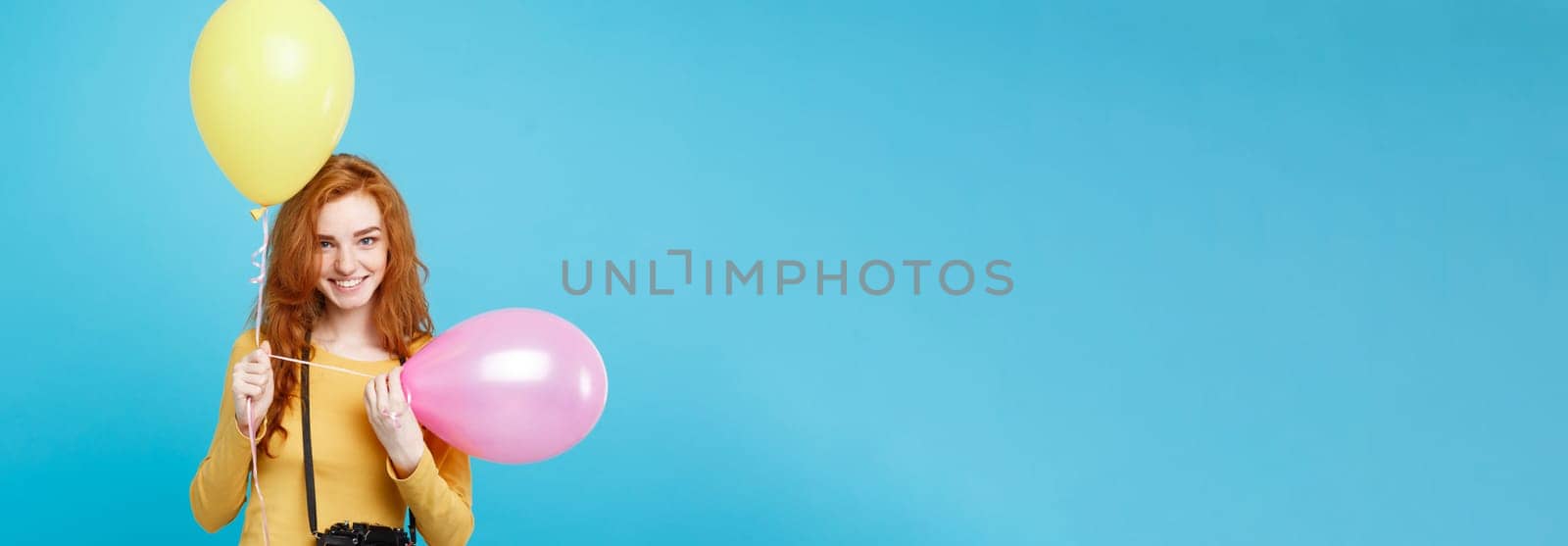 Lifestyle and Party concept - Close up Portrait young beautiful attractive ginger red hair girl with colorful balloon and vintage camera. Blue Pastel Background. Copy space