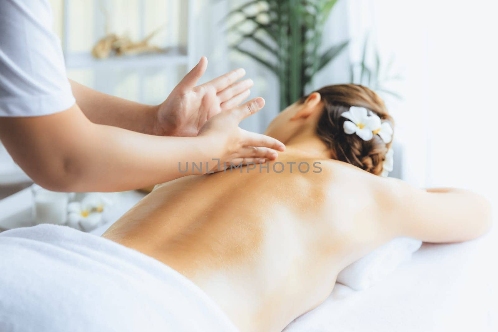 Caucasian woman customer enjoying relaxing anti-stress spa massage and pampering with beauty skin recreation leisure in day light ambient salon spa at luxury resort or hotel. Quiescent