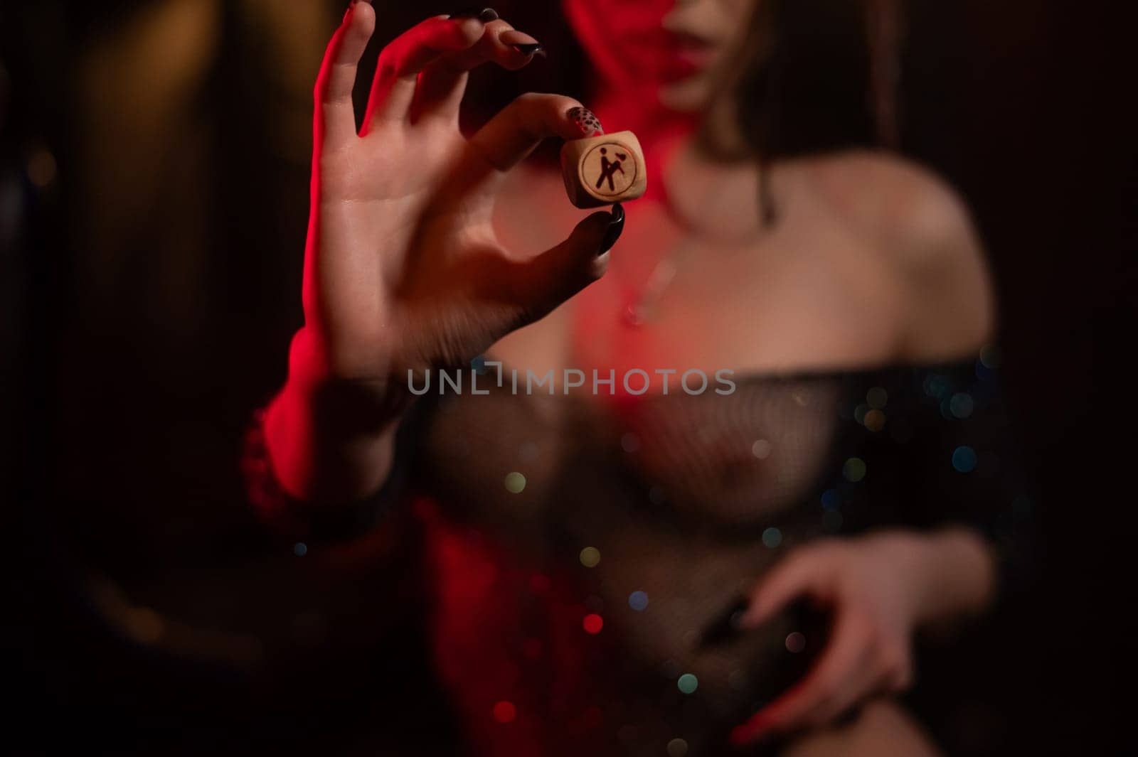 Seductive woman dressed in erotic fishnet holding dice with sex positions